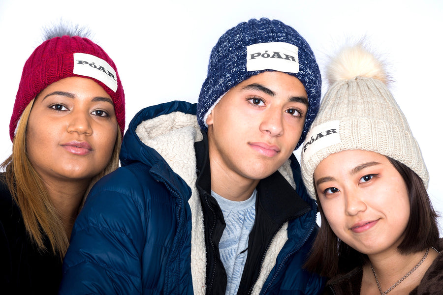Friends wearing PóAR winter beanie hats outdoors